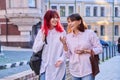 Mother and teenage daughter, walking talking together along city street Royalty Free Stock Photo