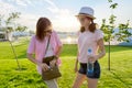 Mother and teenage daughter walking together, mom with bag girl with bottle of water Royalty Free Stock Photo