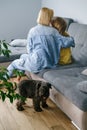 Mother with teenage girl hugging on the sofa with dog Royalty Free Stock Photo