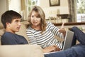 Mother And Teenage Son Arguing On Sofa At Home