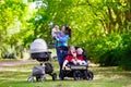 Mother with three children in buggy and stroller Royalty Free Stock Photo