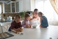 Mother with three children in the kitchen preparing cookies