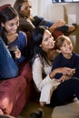 Mother and three children sitting together on sofa Royalty Free Stock Photo