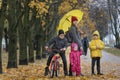 Mother with three children stand in the park in autumn park. Alley with fallen leaves Royalty Free Stock Photo