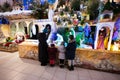 Mother with three children visit Christmas nativity crib scene in church