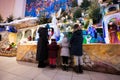 Mother with three children visit Christmas nativity crib scene in church