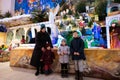 Mother with three children visit Christmas nativity crib scene in church