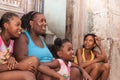 Mother and three daughter sit on doorstep on street in Havana Royalty Free Stock Photo