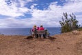 A mother and three kids sitting on a bench at a viewpoint at Ohai trail.
