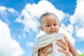 Mother throw up baby daughter with towel on blue sky background Royalty Free Stock Photo