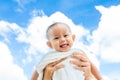 Mother throw up baby daughter with towel on blue sky background Royalty Free Stock Photo