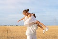 Mother throws up little daughter in air standing wheat field summer day blue sky background Royalty Free Stock Photo