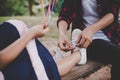 Mother tied shoe for her daughter while sitting on swing relaxing out doors together.