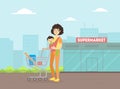 Mother with Toddler Baby in Sling Pushing Shopping Cart, Young Woman With Her Kid Standing in Front of Supermarket Royalty Free Stock Photo