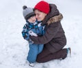 Mother and toddler boy having fun with snow on winter day Royalty Free Stock Photo