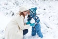 Mother and toddler boy having fun with snow on winter day Royalty Free Stock Photo