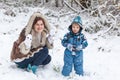 Mother and toddler boy having fun with snow on winter day Royalty Free Stock Photo