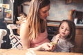 Mother and toddler daughter eating grapes for breakfast at home Royalty Free Stock Photo