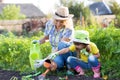 Mother and toddler daughter gardening and watering