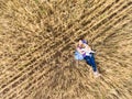 Mother and toddler daughter lying back on dry wheat field, top view from drone, woman embracing her little child Royalty Free Stock Photo