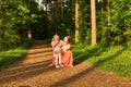 Mother and daughter walk along a path in a park, girl is tired or naughty