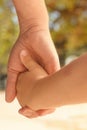 Mother and toddler son holding hands outdoor while walking to park, parental love and closeness with child