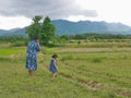 A mother, together with her little baby girl, enjoy spending time in a field in a countryside Royalty Free Stock Photo