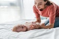 Mother touching cute infant baby while doing massage at home Royalty Free Stock Photo