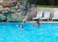 Mother train children to swim in the pool. Royalty Free Stock Photo