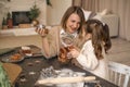 A mother treats daughter to homemade gingerbread Christmas cakes from jar Royalty Free Stock Photo