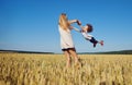 Mother turns a child having fun on the nature in the summer.