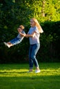 Mother turns little daughter in circle holding her hands