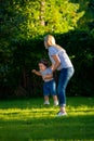 Mother turns little daughter in circle holding her hands