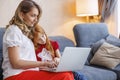 Mother assisting daughter with online lessons using laptop computer