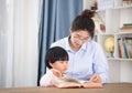 Mother tutoring daughter reading at home