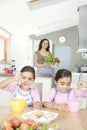 Mother and Twins Beating Eggs in Kitchen Royalty Free Stock Photo