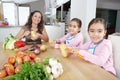 Mother and Twins Peeling Potatoes in Kitchen Royalty Free Stock Photo