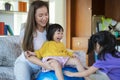 A mother, two Asian daughters, happily playing at home, mother and daughter smiles