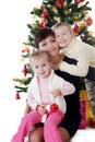 Mother and two children hugging under Christmas tree Royalty Free Stock Photo