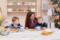 Mother and two children in the kitchen having breakfast. Royalty Free Stock Photo
