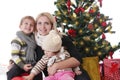 Mother with two children lookig up under Christmas tree Royalty Free Stock Photo