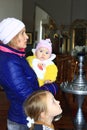 Mother with two children is praying in church. Family prayer. Faith in God