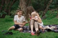 Mother and two children rest in Park. Family Picnic at garden outdoors