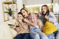 Mother and two children sitting on sofa at home watching TV together Royalty Free Stock Photo