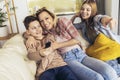 Mother and two children sitting on sofa at home watching TV together Royalty Free Stock Photo