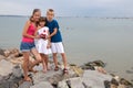 Mother and two children son and daughter standing together on big boulders on sea shore Royalty Free Stock Photo