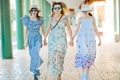 Mother and two daughters briskly walking hand in hand at colonnade