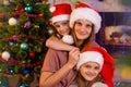 Mother and two daughters at the Christmas tree Royalty Free Stock Photo