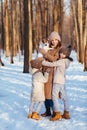 Mother with two daughters and dog in snowy forest Royalty Free Stock Photo