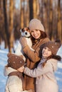 Mother with two daughters and dog in snowy forest Royalty Free Stock Photo